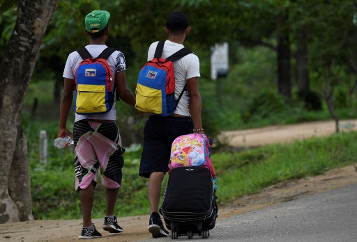 Venezuelans walk in Arauca, Colombia, on border with Venezuela, on May 15, 2019. - Venezuelan migrants find anti-personnel mines, forced recruitment of armed groups, trafficking networks in Colombia. Vulnerable, the migrants are cannon fodder of all traffics. (Photo by Juan BARRETO / AFP)